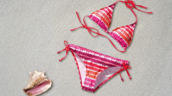 Orange, pink, and white string bikini on a white background with a seashell.