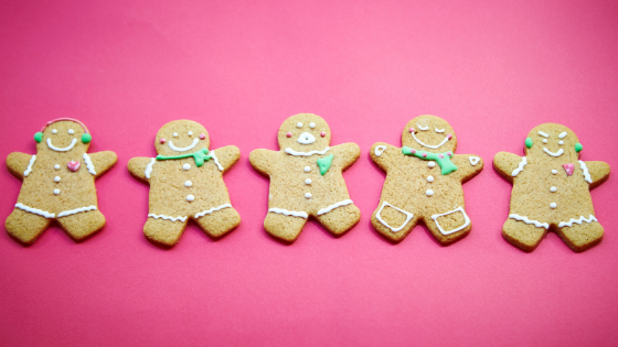 Pink background with a line of 5 gingerbread cookies.