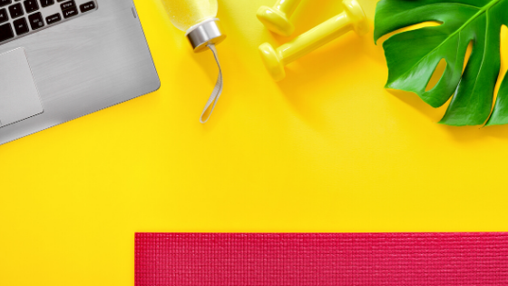 Bright yellow background with a red yoga mat, yellow dumbbells, yellow water bottle, green plant, and a laptop.