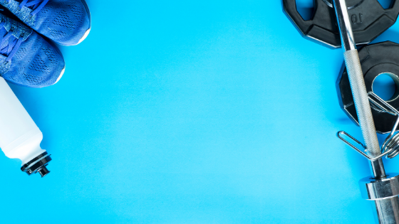 Bright blue background with darker blue sneakers, a blue water bottle, and a barbell and plates.